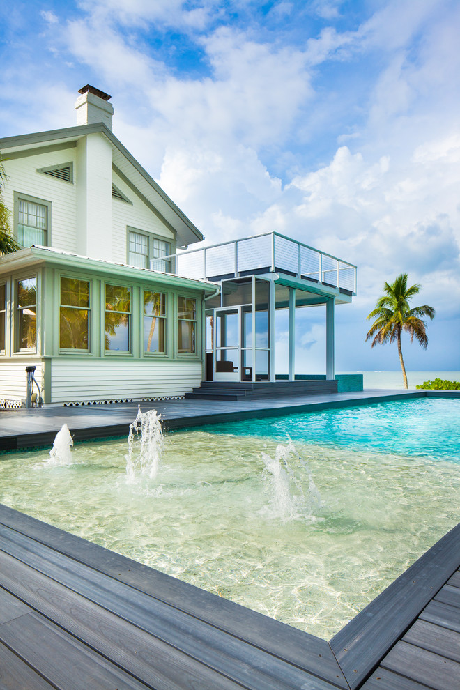 Idee per una grande piscina monocorsia stile marino rettangolare dietro casa con fontane e pedane