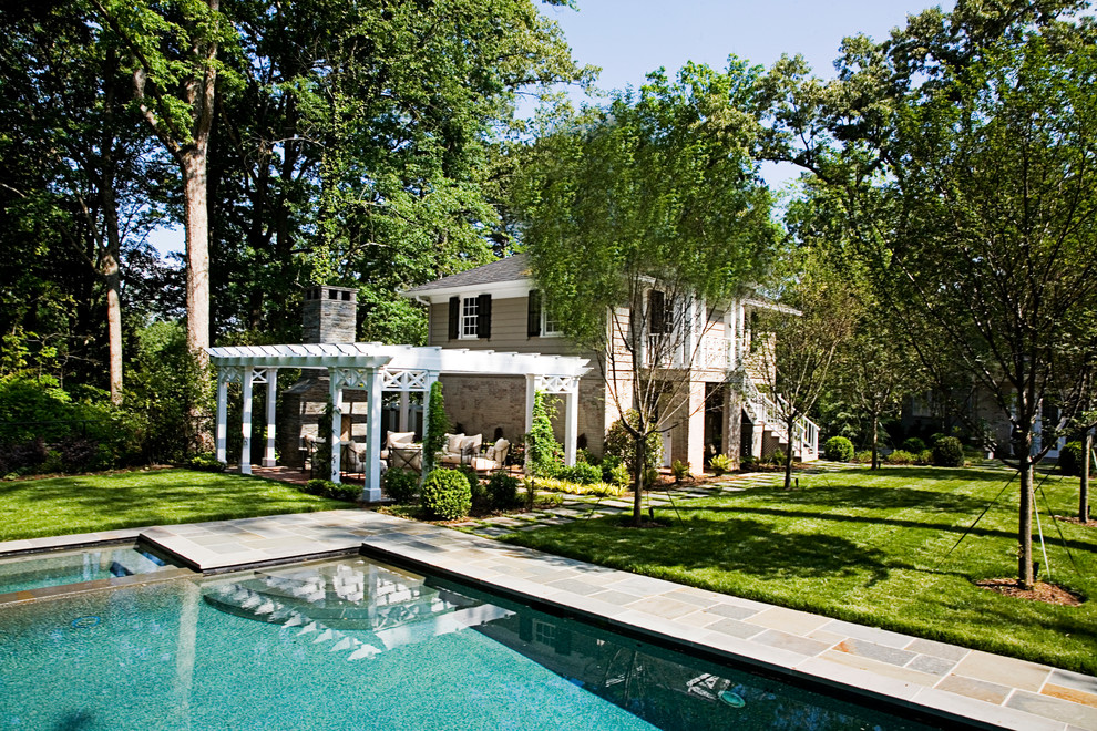 Exempel på en klassisk pool på baksidan av huset, med naturstensplattor