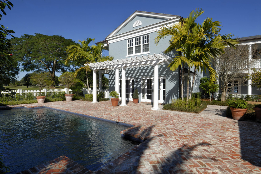 Traditional swimming pool in Miami with brick paving.