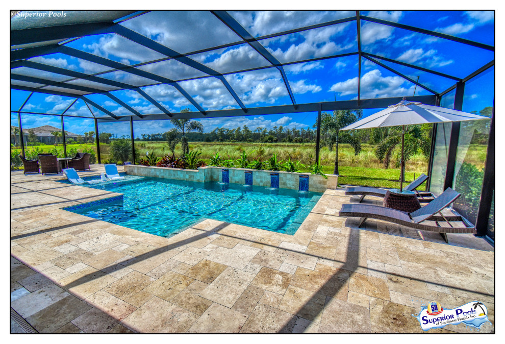 Ejemplo de piscina actual de tamaño medio rectangular en patio trasero con paisajismo de piscina y adoquines de piedra natural