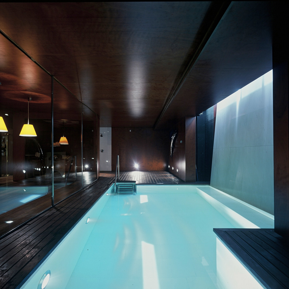 Esempio di una piscina coperta minimalista a "L" di medie dimensioni con fontane e pedane