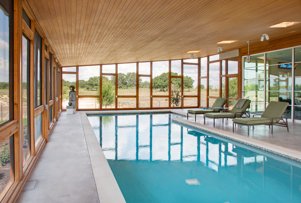 Пример оригинального дизайна: спортивный, прямоугольный бассейн среднего размера в доме в стиле модернизм с покрытием из бетонных плит