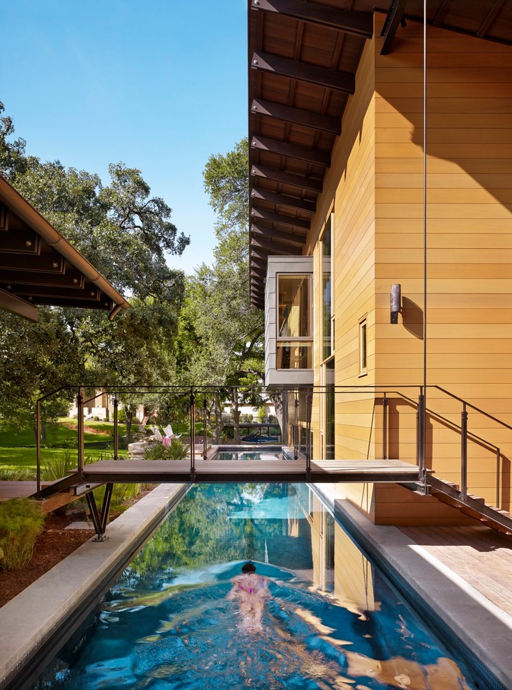 Foto de piscina alargada contemporánea rectangular en patio lateral