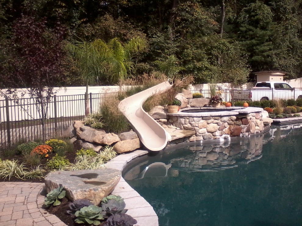 Example of a mid-sized classic backyard concrete paver and custom-shaped water slide design in New York