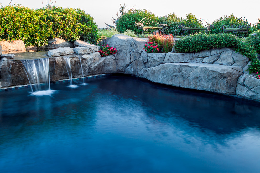 Ispirazione per una grande piscina country personalizzata dietro casa con fontane e cemento stampato