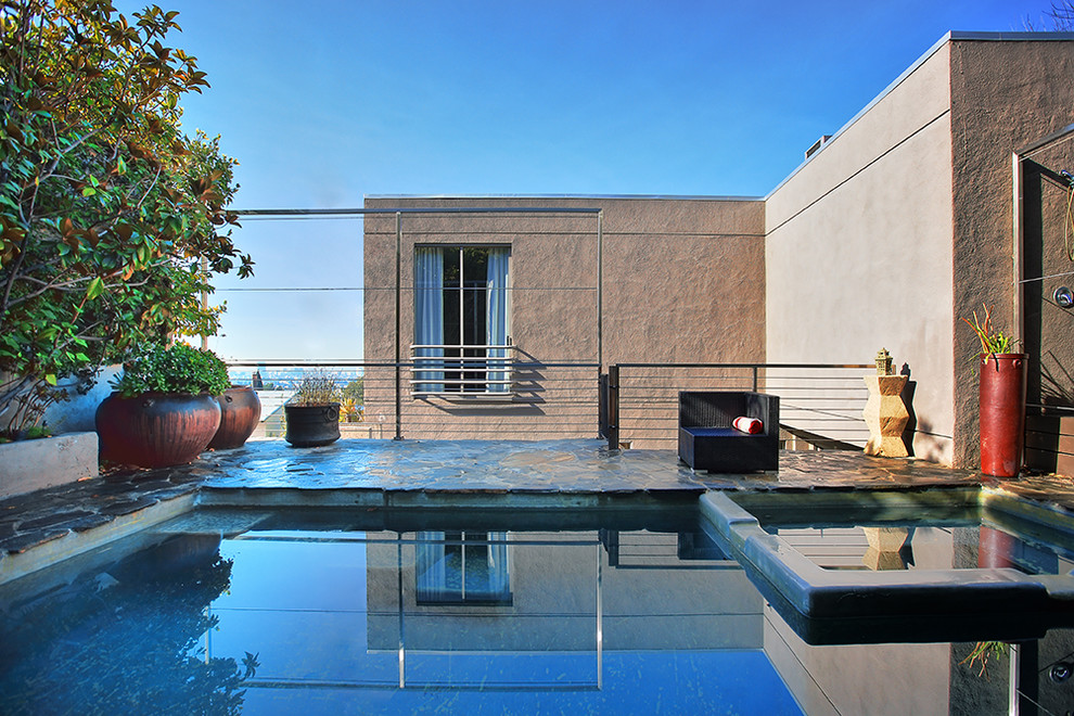 Пример оригинального дизайна: прямоугольный бассейн на крыше в современном стиле с фонтаном и покрытием из каменной брусчатки