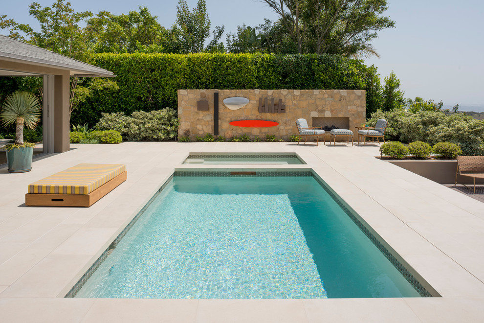 Esempio di una piscina monocorsia design rettangolare di medie dimensioni e dietro casa con una vasca idromassaggio e lastre di cemento