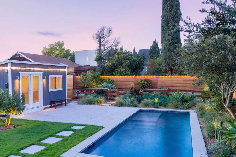 Esempio di una piscina naturale minimalista rettangolare di medie dimensioni e dietro casa con pavimentazioni in cemento