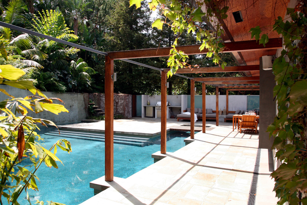 Esempio di una grande piscina moderna rettangolare dietro casa con piastrelle