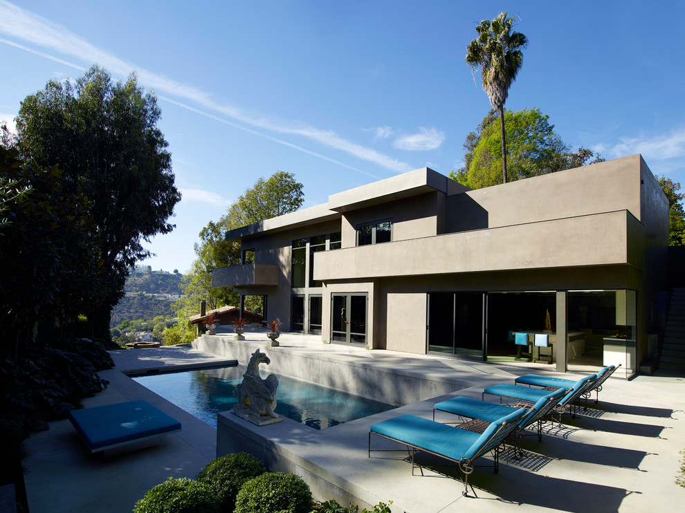 Idee per una grande piscina monocorsia contemporanea rettangolare dietro casa con lastre di cemento