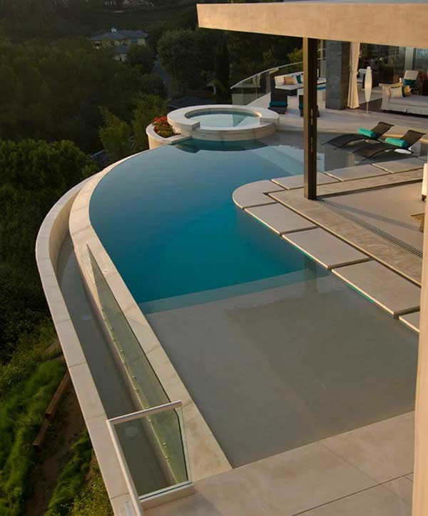 Esempio di una grande piscina a sfioro infinito moderna dietro casa con una vasca idromassaggio