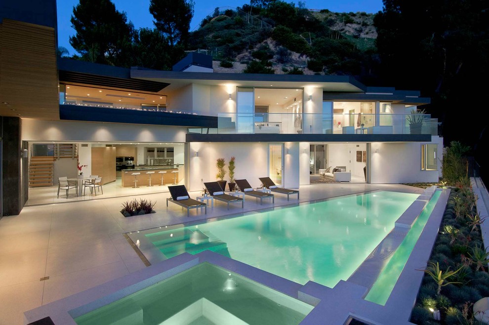 Imagen de piscinas y jacuzzis alargados minimalistas extra grandes rectangulares en patio trasero con losas de hormigón