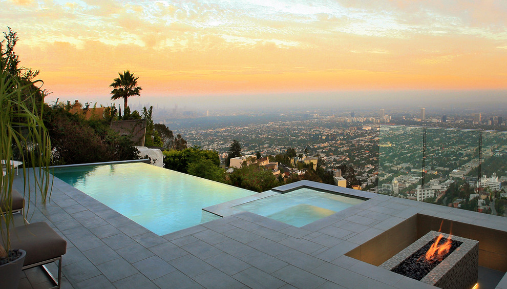 Large minimalist backyard tile and rectangular infinity hot tub photo in Los Angeles