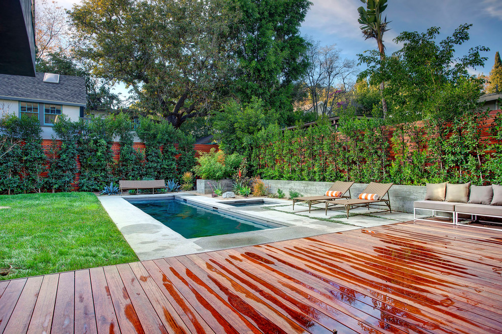 Cette image montre un petit couloir de nage arrière minimaliste rectangle avec une terrasse en bois.
