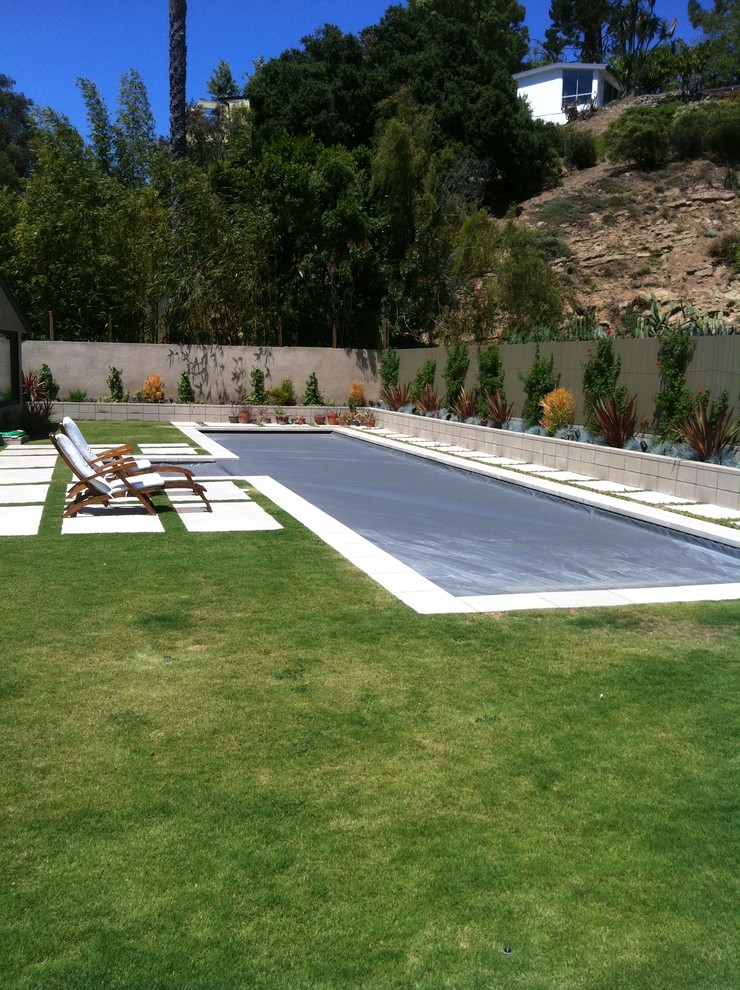 Imagen de piscina alargada actual de tamaño medio rectangular con suelo de baldosas