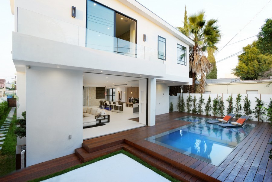 Example of a mid-sized minimalist backyard rectangular infinity pool design in Los Angeles with decking