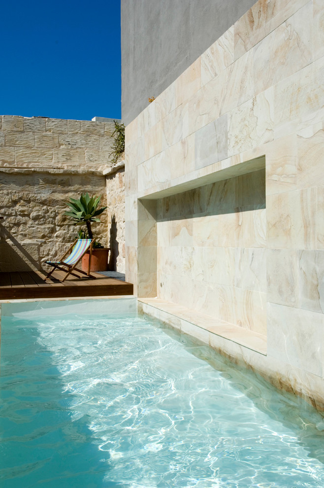 Idée de décoration pour une piscine design avec une terrasse en bois.