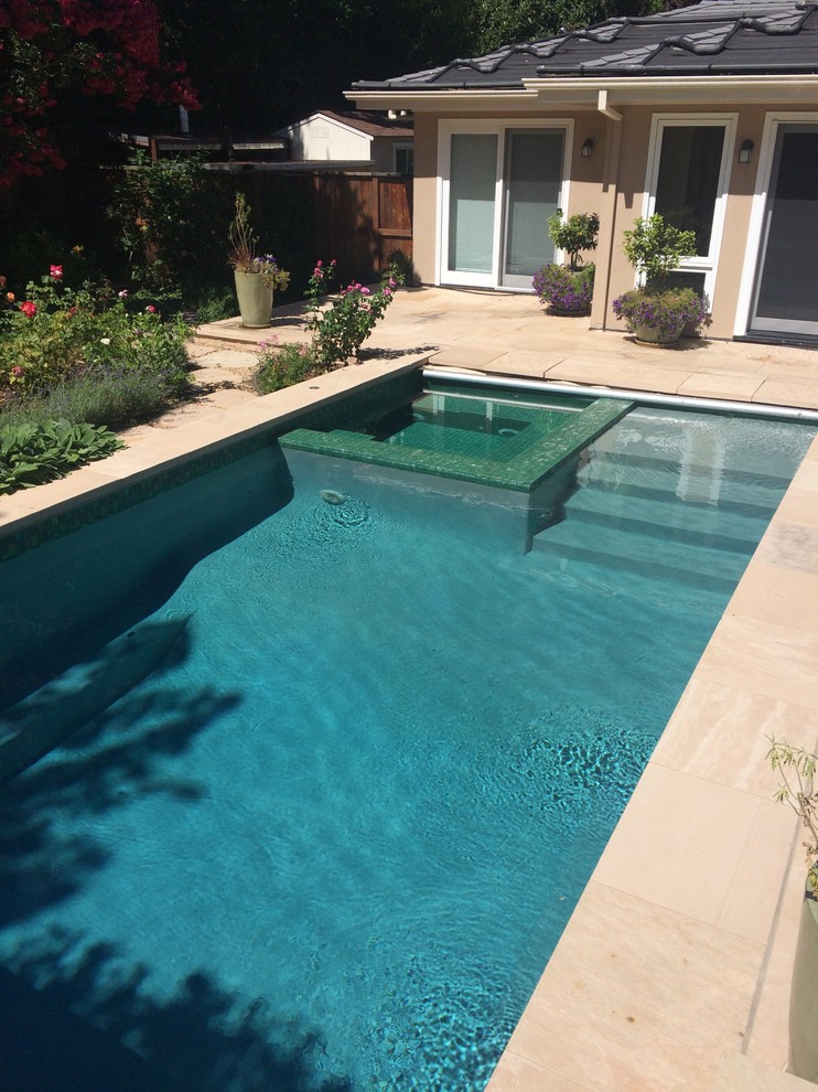 На фото: прямоугольный бассейн среднего размера на заднем дворе в стиле неоклассика (современная классика) с джакузи и покрытием из плитки