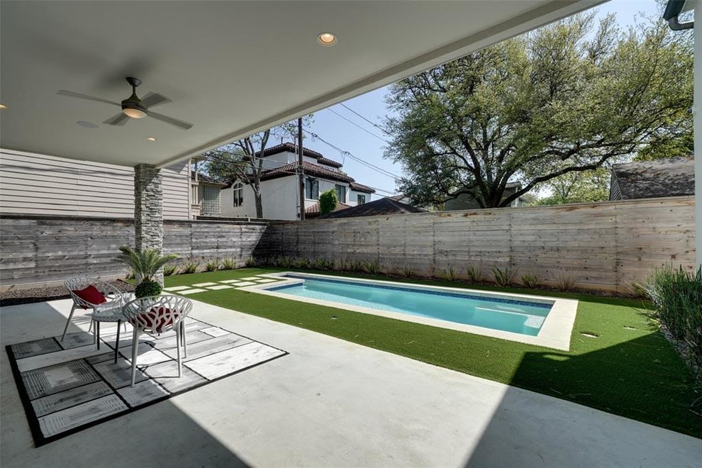 Ejemplo de piscina alargada moderna de tamaño medio rectangular en patio trasero con adoquines de hormigón