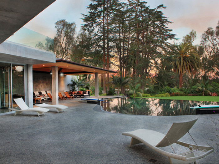 Photo of a large contemporary back custom shaped infinity swimming pool in Santa Barbara with a water slide and concrete slabs.