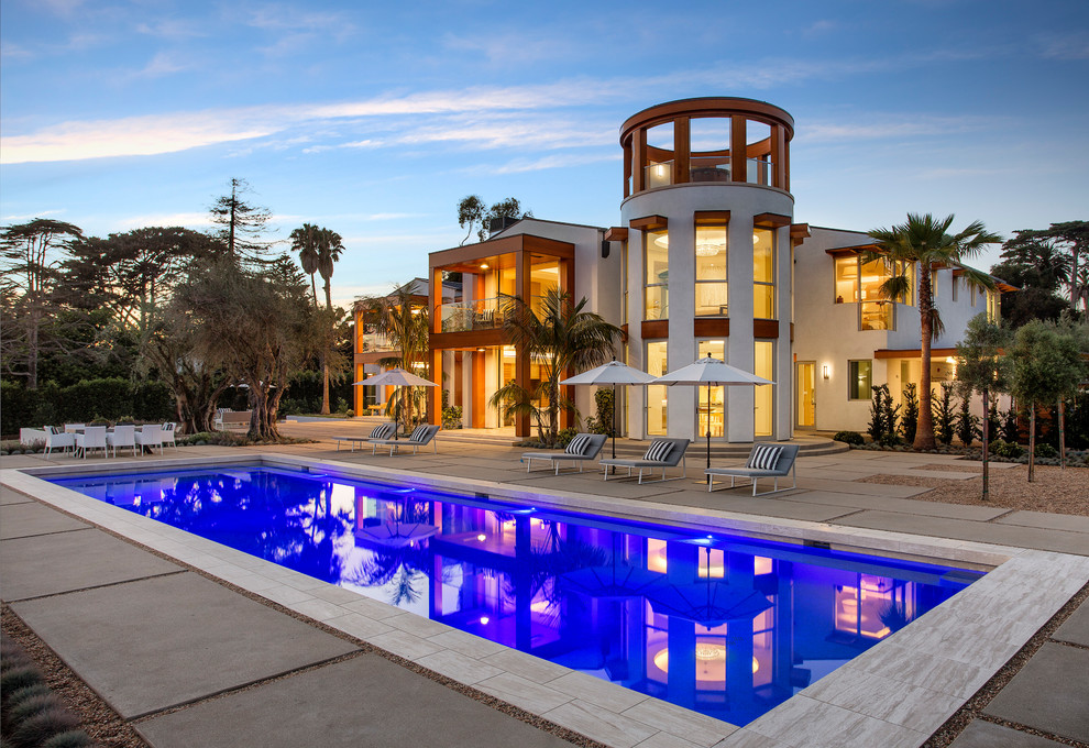 Immagine di una piscina moderna rettangolare dietro casa con lastre di cemento