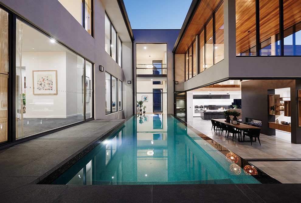 Стильный дизайн: большой прямоугольный бассейн-инфинити на заднем дворе в современном стиле с фонтаном и покрытием из плитки - последний тренд