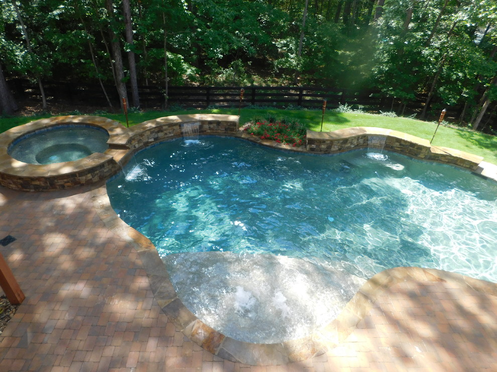 Идея дизайна: естественный бассейн среднего размера, произвольной формы на заднем дворе в стиле рустика с джакузи и мощением клинкерной брусчаткой