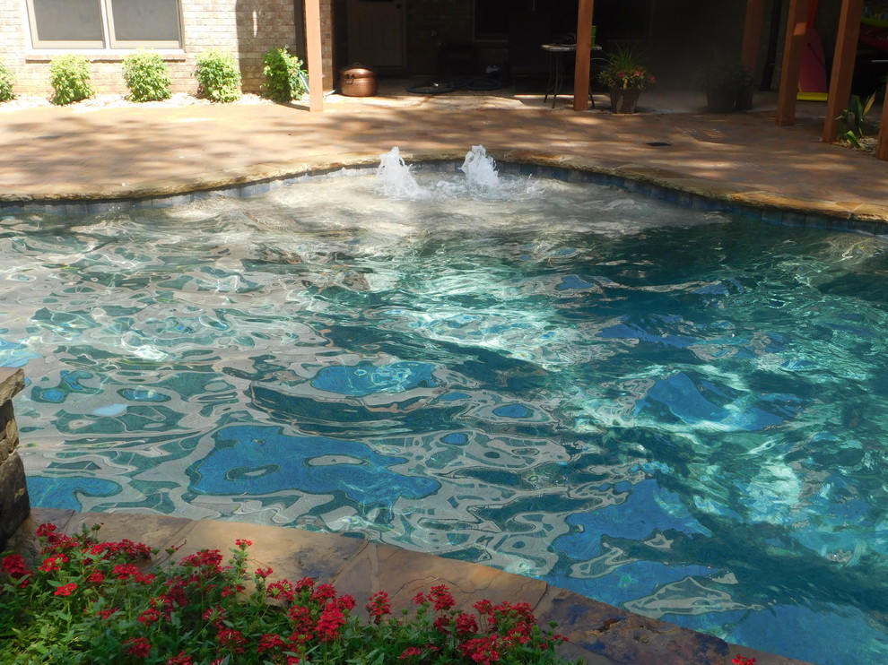 Exemple d'une piscine naturelle et arrière montagne de taille moyenne et sur mesure avec un bain bouillonnant et des pavés en brique.
