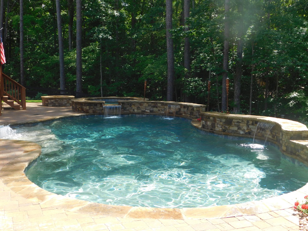 Photo of a medium sized rustic back custom shaped natural hot tub in Atlanta with brick paving.
