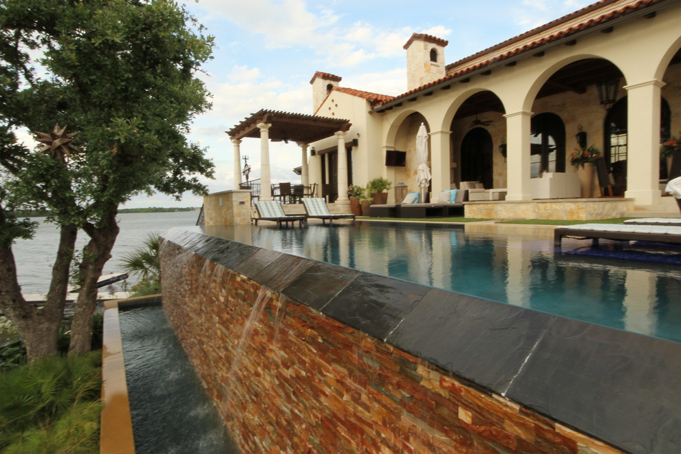 Свежая идея для дизайна: большой прямоугольный бассейн-инфинити на заднем дворе в средиземноморском стиле с фонтаном и покрытием из каменной брусчатки - отличное фото интерьера