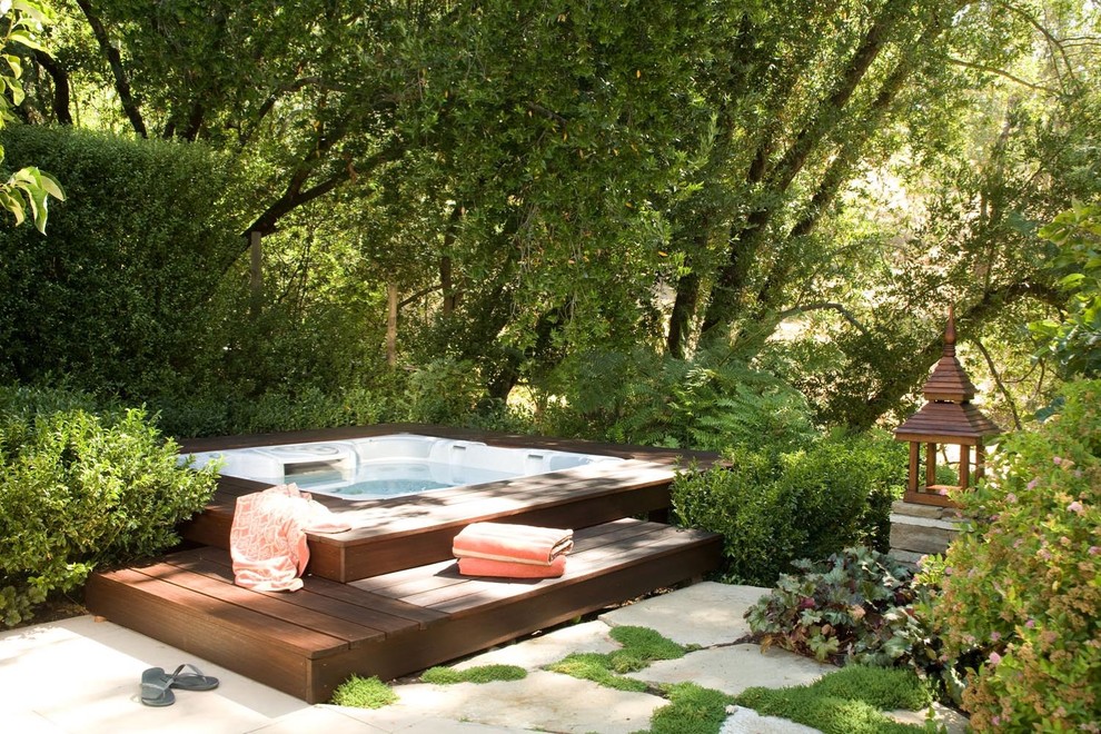 Diseño de piscinas y jacuzzis elevados tradicionales de tamaño medio rectangulares en patio trasero con adoquines de hormigón
