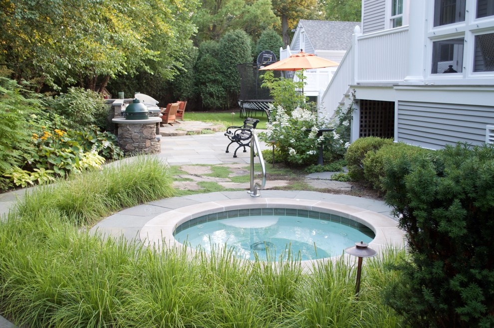 Inspiration för en stor vintage rund pool på baksidan av huset, med spabad och naturstensplattor