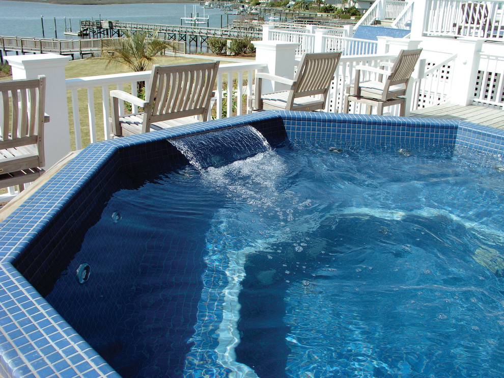 Immagine di una piscina fuori terra stile marino con fontane e pedane