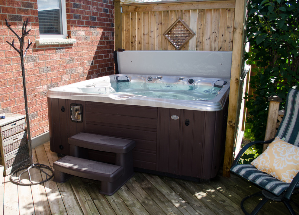 Esempio di una piscina fuori terra classica personalizzata di medie dimensioni e dietro casa con una vasca idromassaggio e pedane