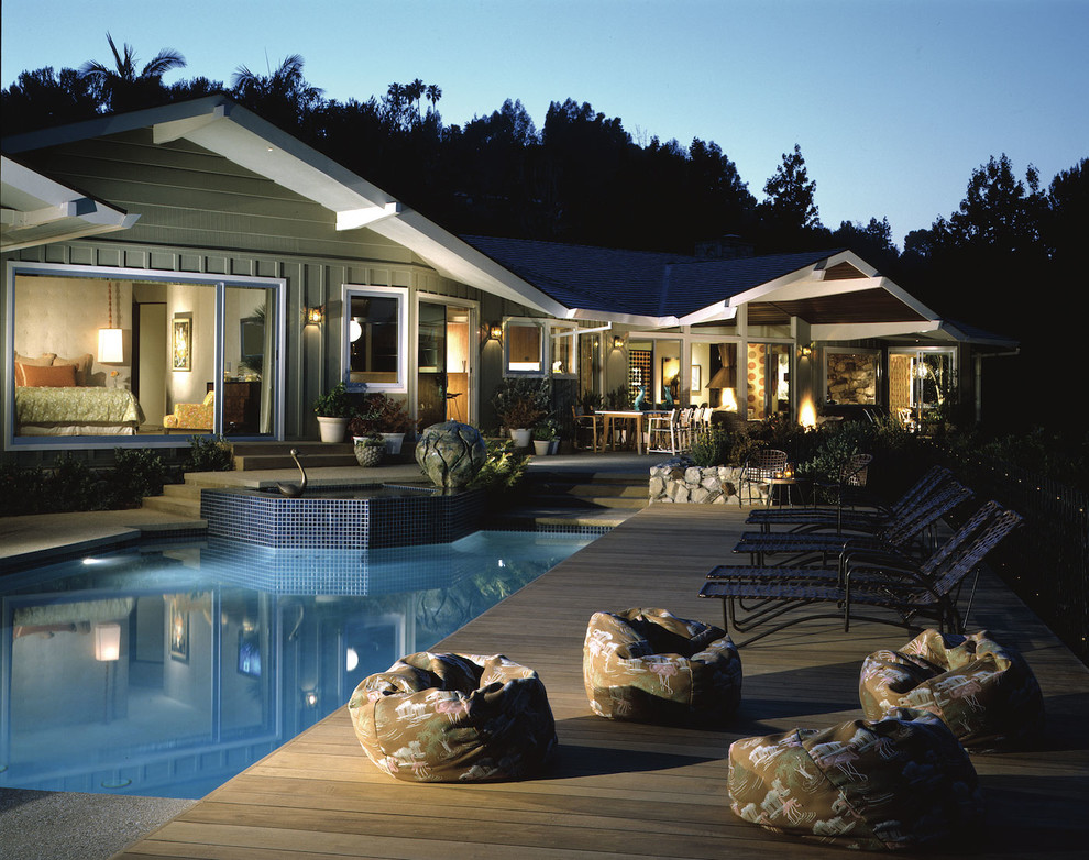 Diseño de piscinas y jacuzzis alargados retro de tamaño medio rectangulares en patio trasero con entablado