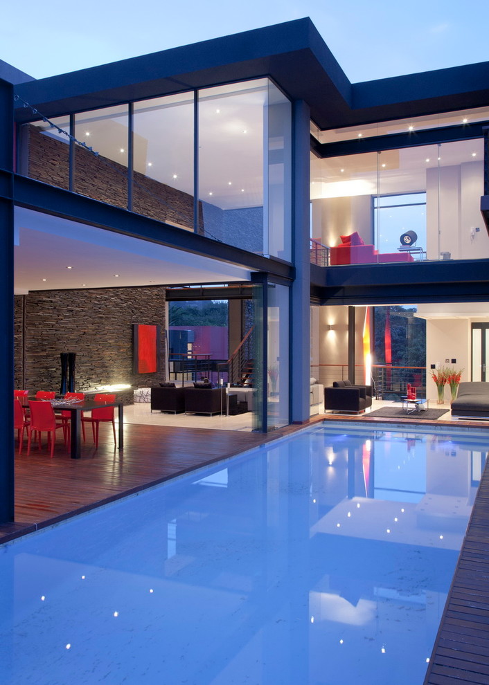 Inspiration pour une piscine design rectangle avec une terrasse en bois.