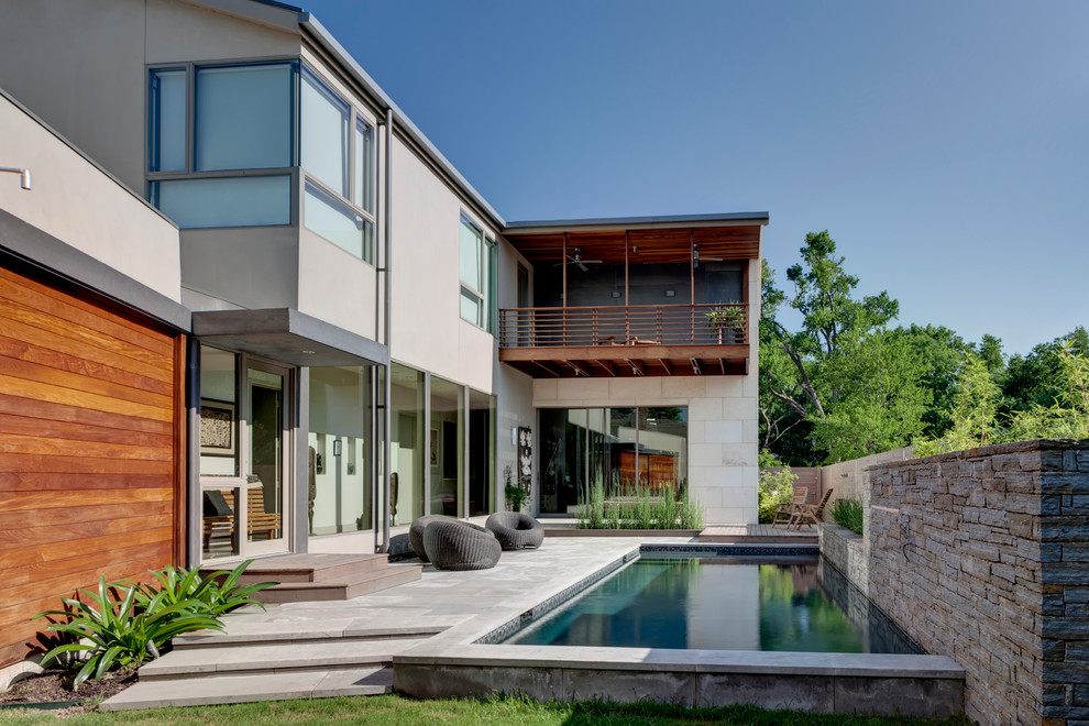 Inspiration för mellanstora moderna rektangulär pooler längs med huset, med naturstensplattor