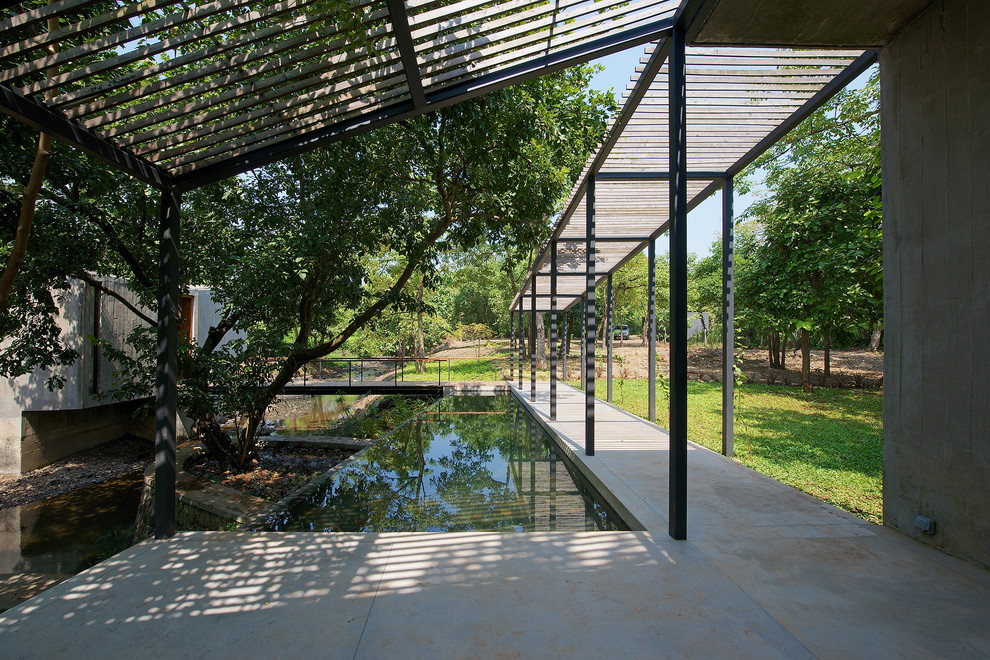 Esempio di una piscina a sfioro infinito minimalista rettangolare di medie dimensioni con lastre di cemento