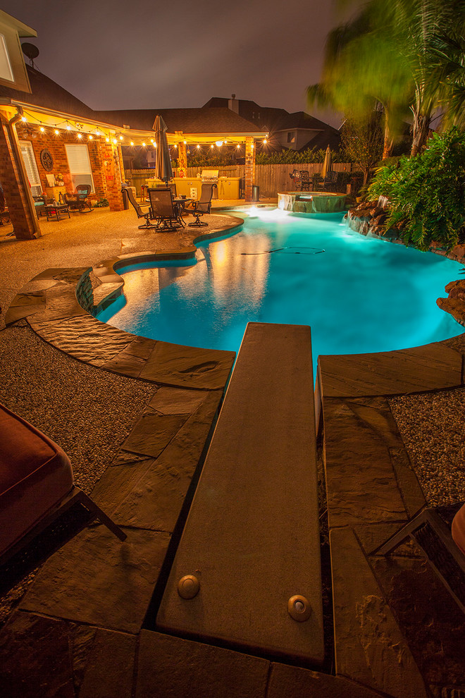 Esempio di una grande piscina design personalizzata dietro casa con pedane