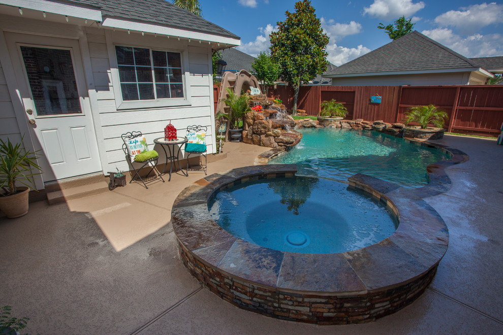Cette image montre une piscine arrière ethnique de taille moyenne et sur mesure avec un toboggan et une terrasse en bois.
