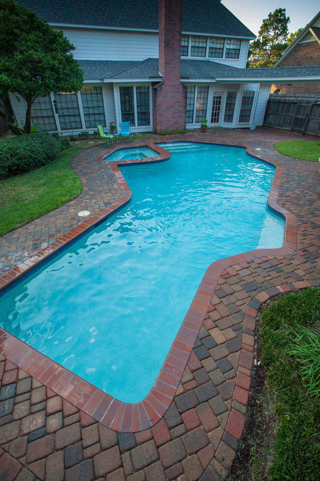 Großer Klassischer Pool hinter dem Haus in individueller Form mit Pflastersteinen in Houston