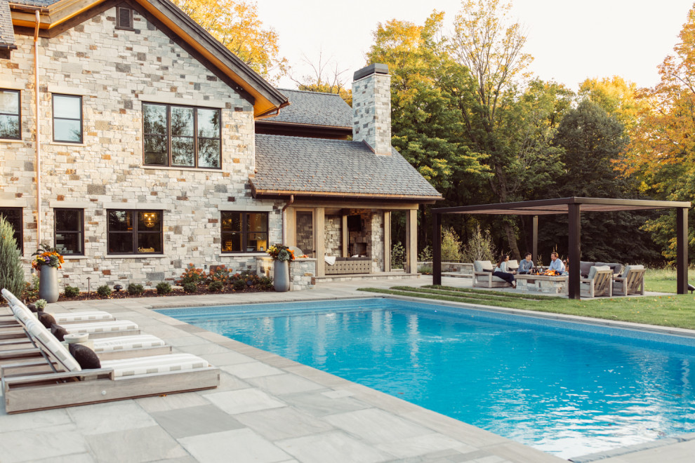 Expansive modern back rectangular swimming pool in Minneapolis with natural stone paving.