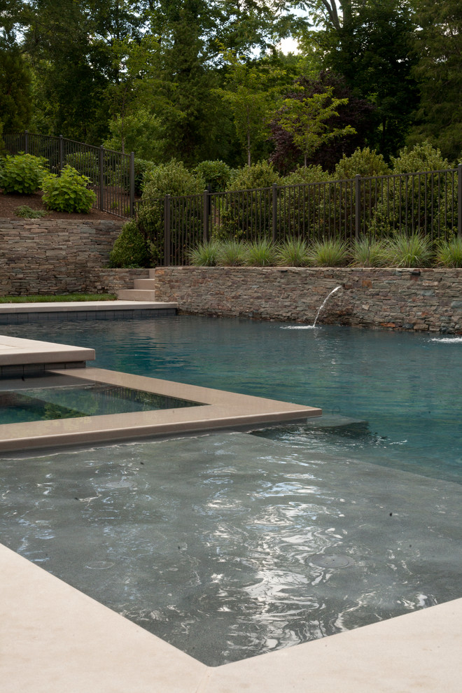 Diseño de piscinas y jacuzzis alargados modernos de tamaño medio en forma de L en patio trasero con adoquines de hormigón