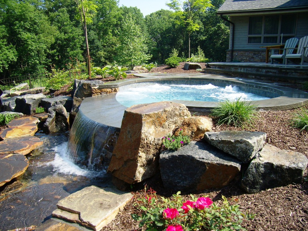 Idee per una piscina naturale tradizionale personalizzata dietro casa con fontane e pavimentazioni in pietra naturale