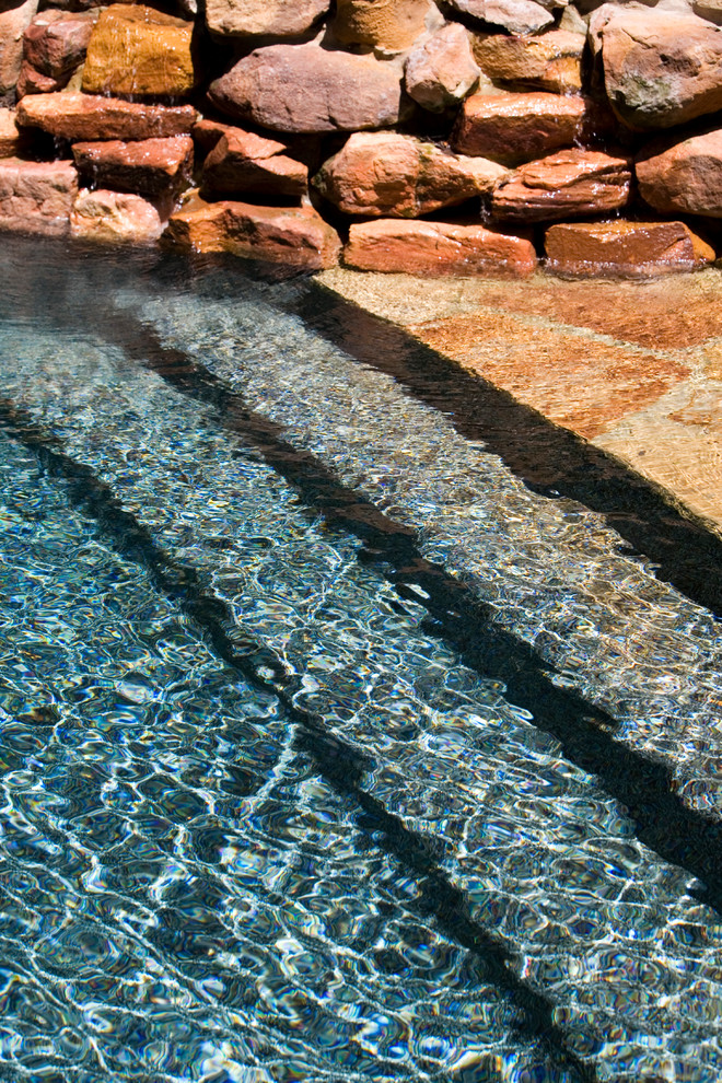 Idées déco pour une piscine arrière et naturelle classique sur mesure et de taille moyenne avec des pavés en pierre naturelle et un bain bouillonnant.