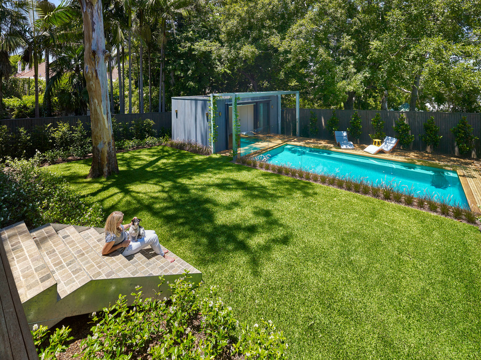 Стильный дизайн: спортивный, прямоугольный бассейн на заднем дворе в стиле модернизм с домиком у бассейна - последний тренд
