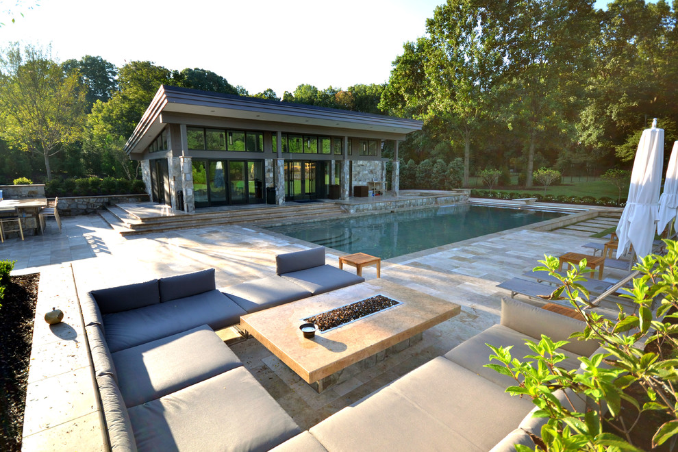 Imagen de casa de la piscina y piscina alargada moderna grande rectangular en patio trasero con adoquines de piedra natural