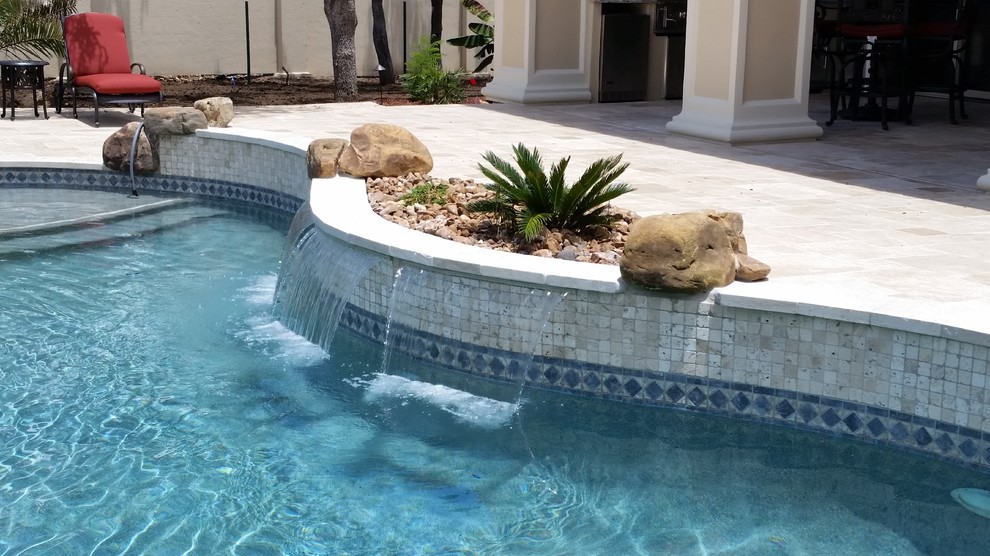 Идея дизайна: большой естественный бассейн в форме фасоли на заднем дворе в средиземноморском стиле с джакузи и покрытием из каменной брусчатки