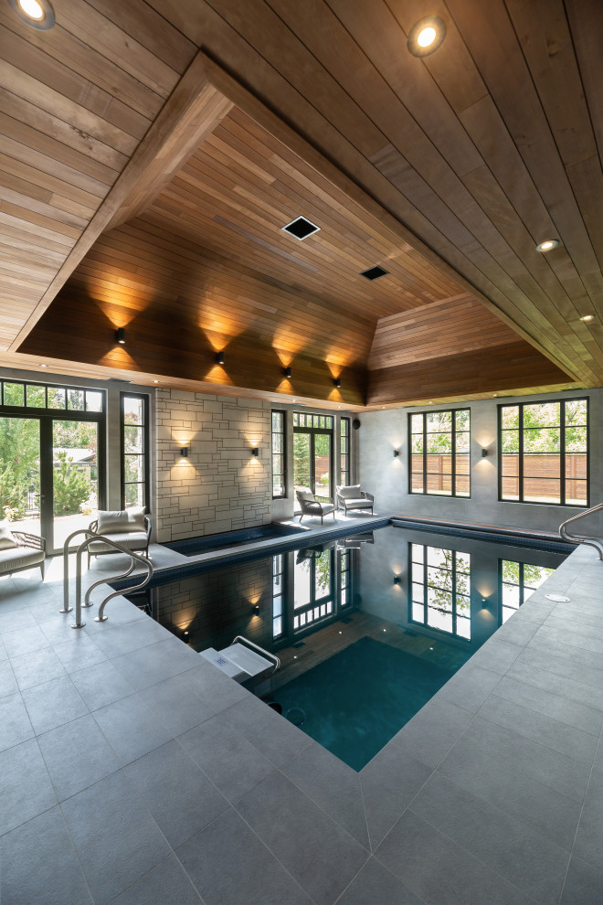 На фото: прямоугольный бассейн в доме в современном стиле с покрытием из плитки с