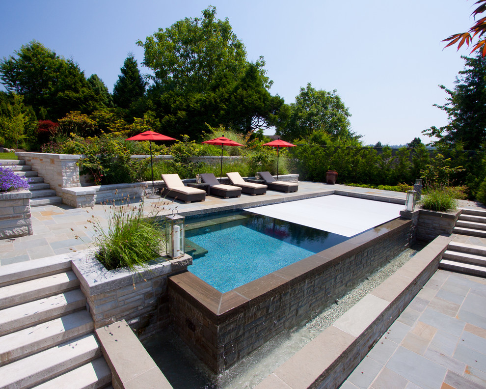 Modelo de piscina con fuente infinita contemporánea rectangular en patio lateral